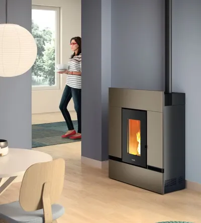Poêle à granulés Cadel Mithos Plus 12 Up-Twin installé dans une pièce, finition Acier Light Bronze